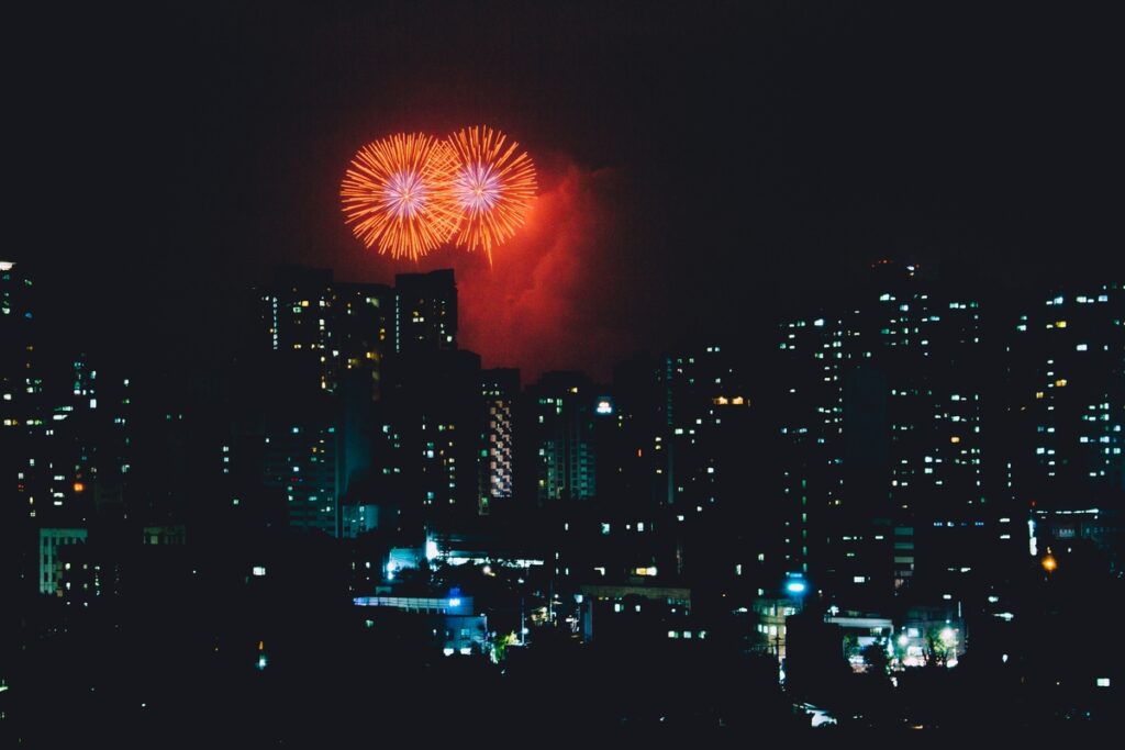 Fireworks explode over skyscrapers at night